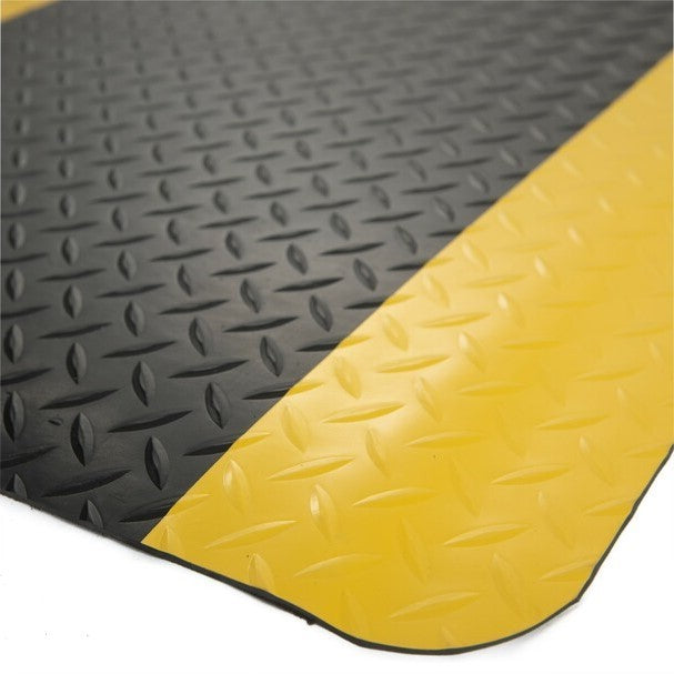 Close-up of the Dolphy anti-fatigue mat's diamond-plate surface and yellow safety edge