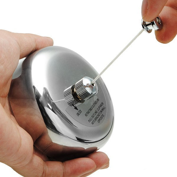 Hand pulling the steel line out of the Dolphy mirror-finish retractable clothesline