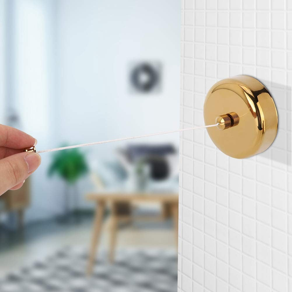Dolphy gold retractable clothesline on a tiled wall with the line being pulled out