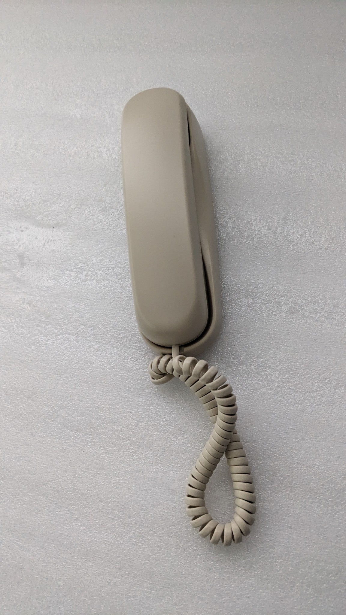Dolphy ivory slimline telephone with the handset on its base