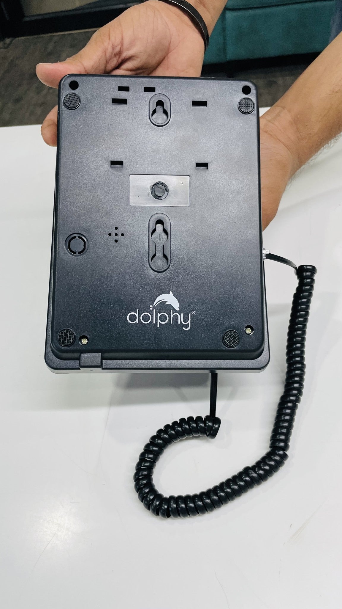 Back of the Dolphy black telephone base showing the wall-mount keyholes