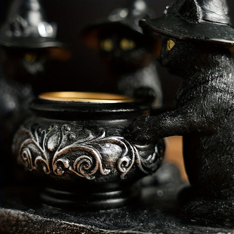 Black resin witch cat figurine in a pointed hat beside a cauldron with a brass rim