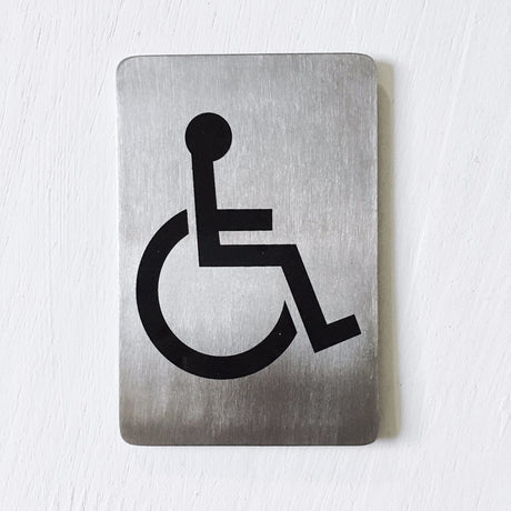 Stainless steel sign with a black wheelchair access symbol