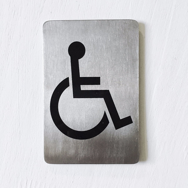Stainless steel sign with a black wheelchair access symbol