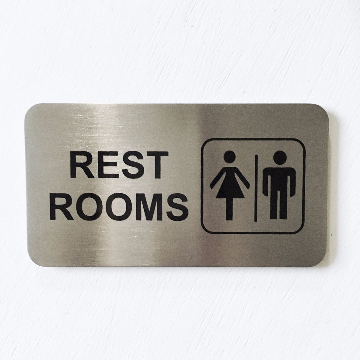 Stainless steel REST ROOMS sign with male and female symbols