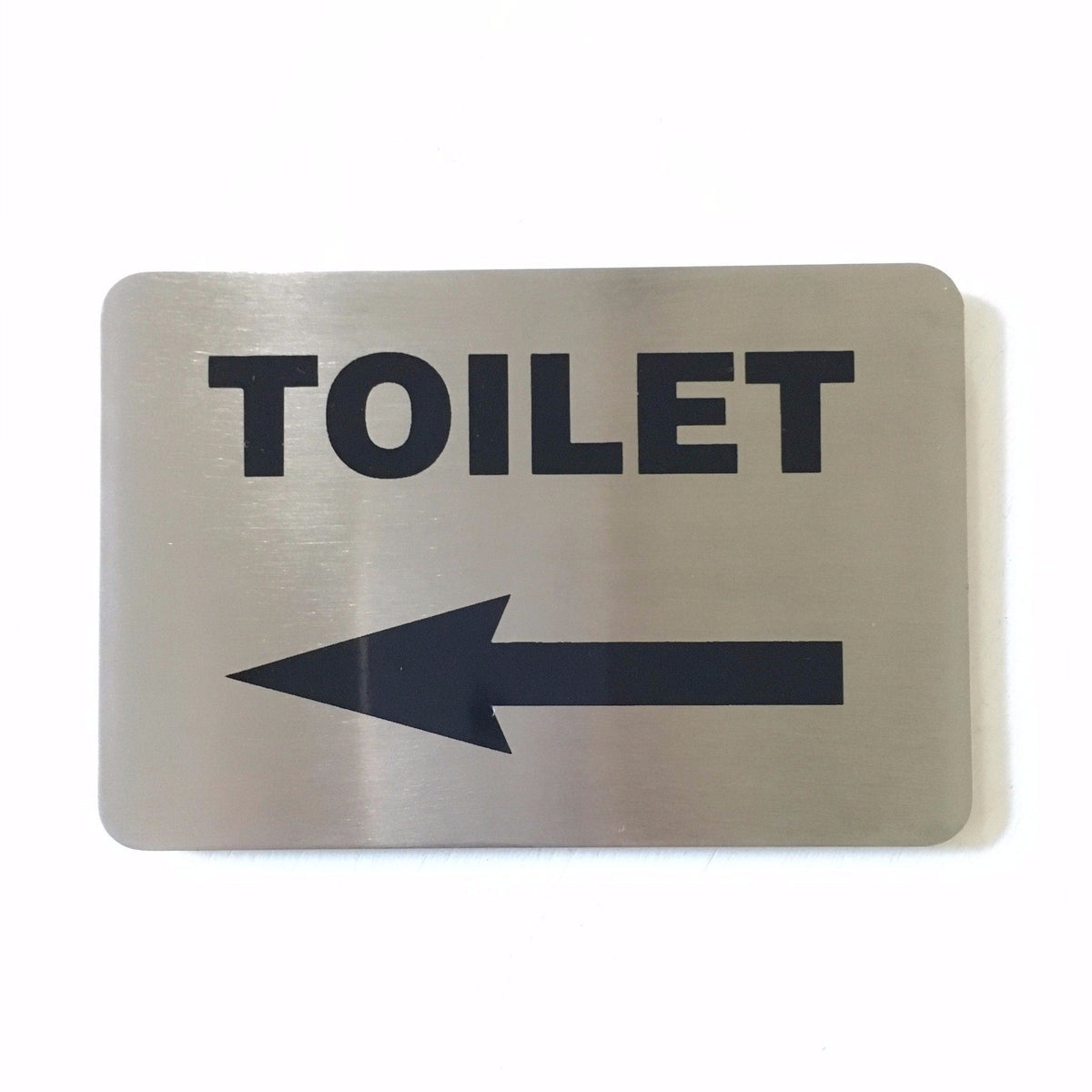 Stainless steel TOILET sign with an arrow pointing left