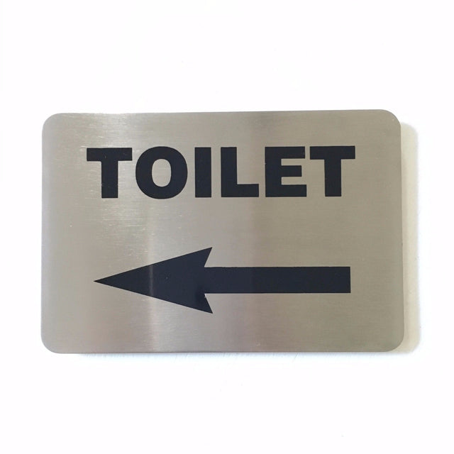 Stainless steel TOILET sign with an arrow pointing left