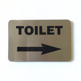 Stainless steel TOILET sign with an arrow pointing right