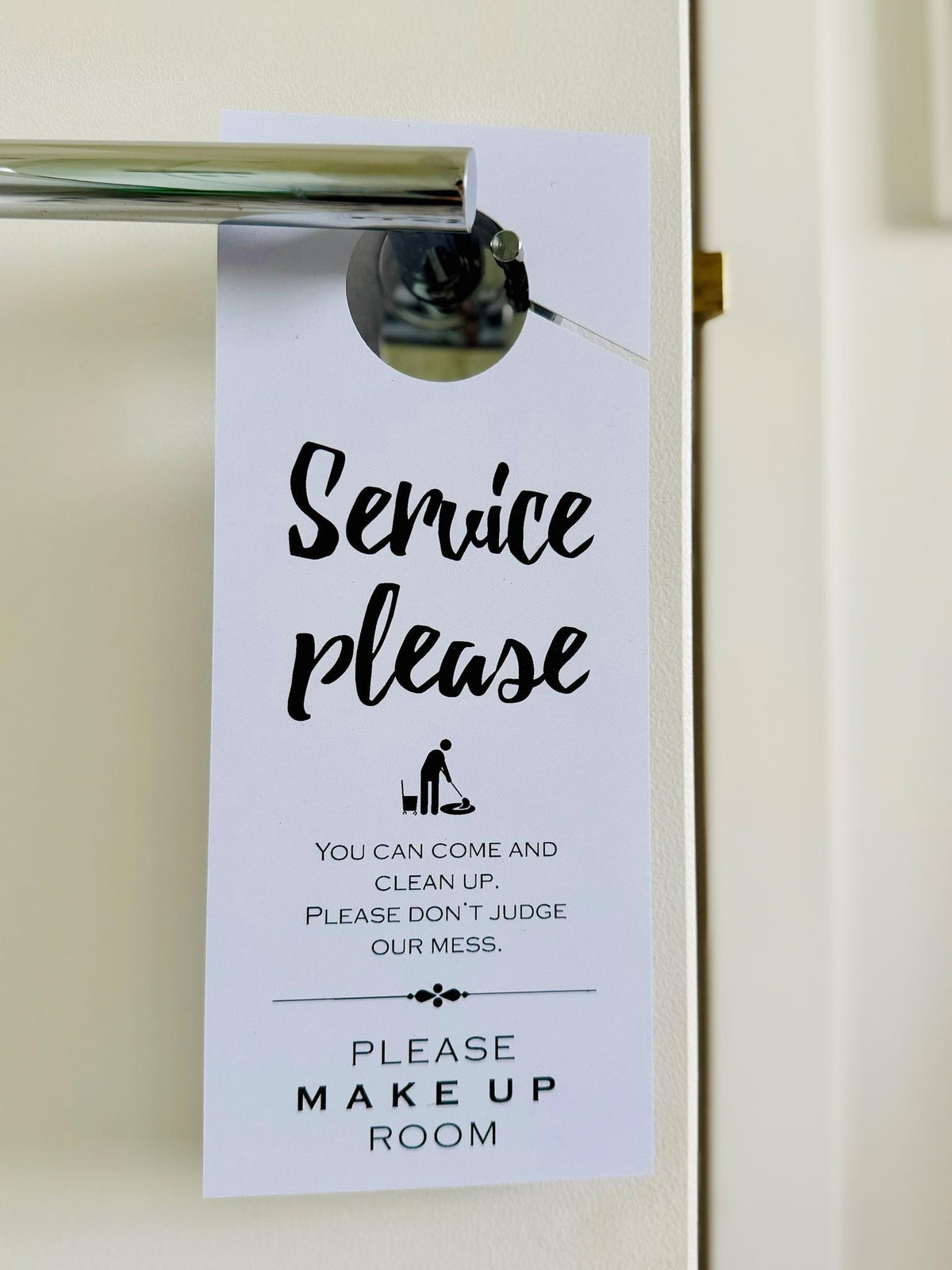Service Please door hanger hanging on a hotel door handle