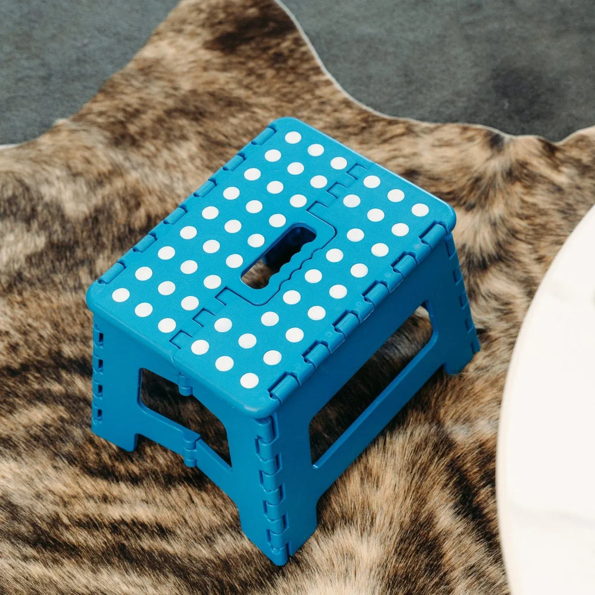 Blue plastic folding chair, with a carry handle.