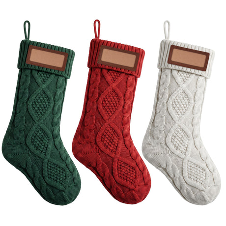 Three knitted solid colour Christmas stockings with leather name patches.