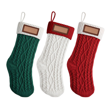 Three knitted Christmas stockings in contrasting colours with leather name patches.