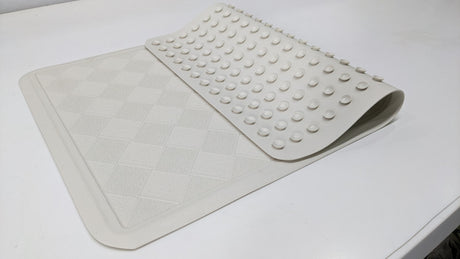 Dolphy rubber bath mat with one end folded back to show the suction cups underneath