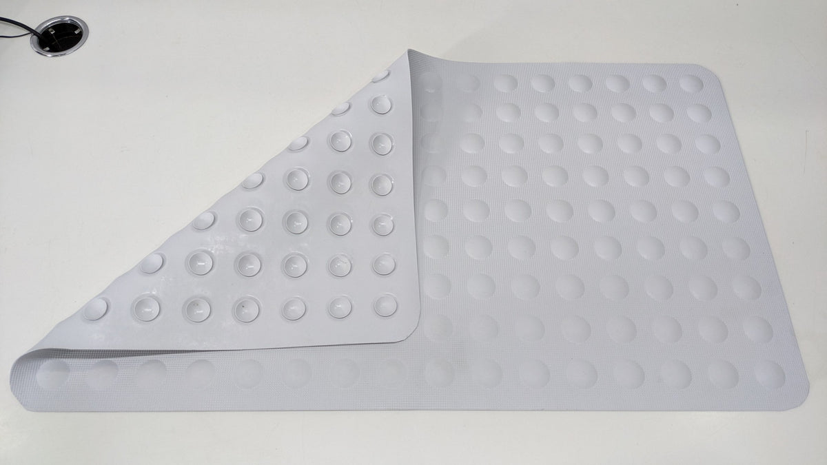 Dolphy bath mat with a corner folded back to show the suction cups underneath