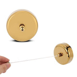 Hand pulling the line from the Dolphy gold round retractable clothesline