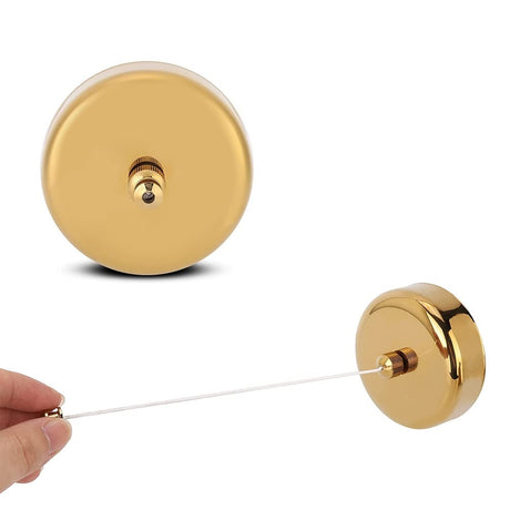 Hand pulling the line from the Dolphy gold round retractable clothesline