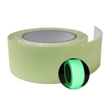 Dolphy glow tape unrolled beside a roll glowing green in the dark