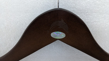 Close-up of the Dolphy logo engraved on the brown timber hanger