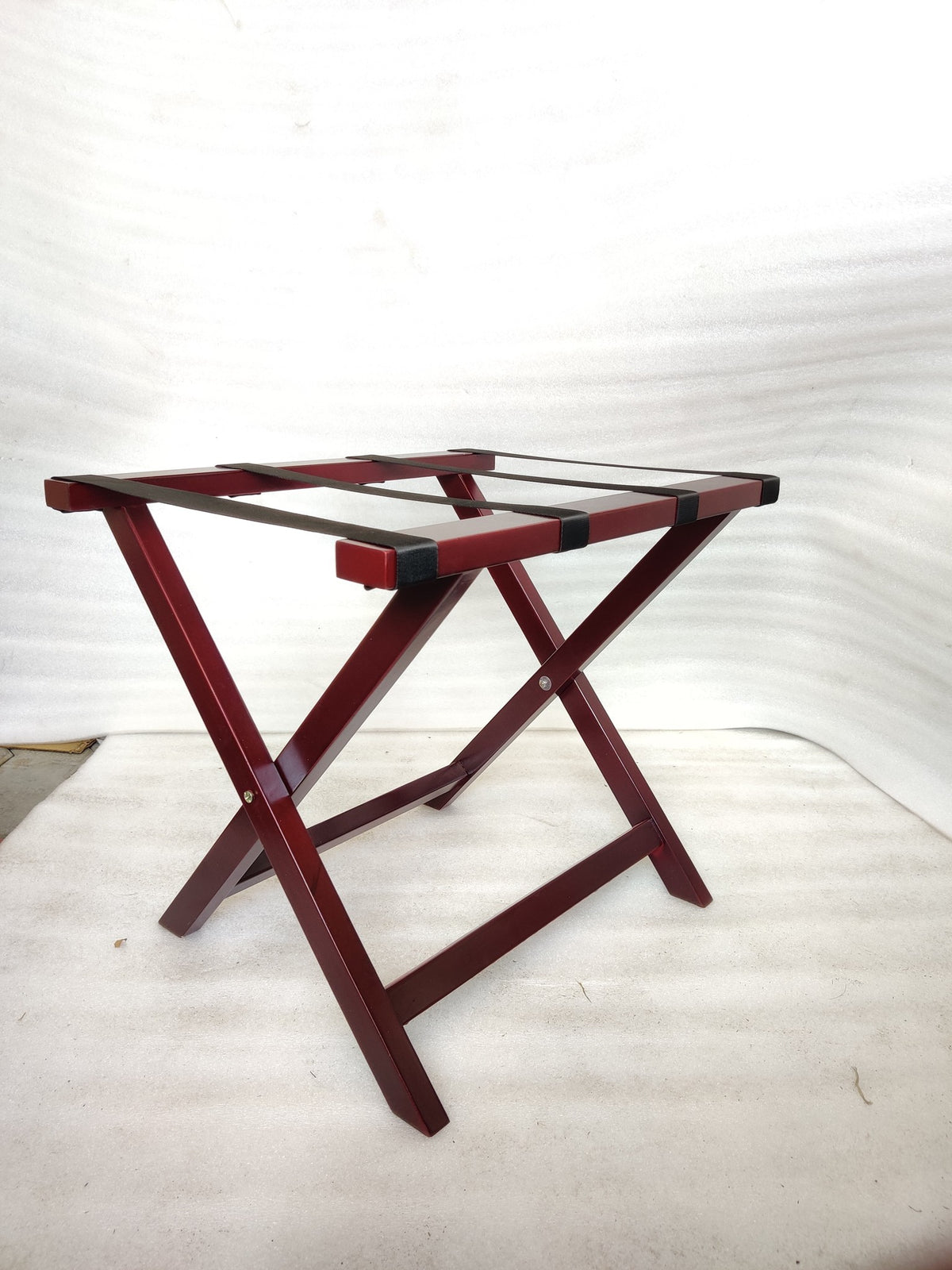 Dolphy cherry red wooden folding luggage rack open, angled view with black straps