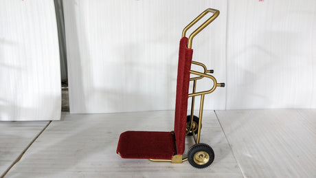 Dolphy gold and red foldable luggage trolley standing upright, side view