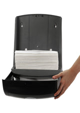 Dolphy black towel dispenser opened, showing a stack of multifold towels inside