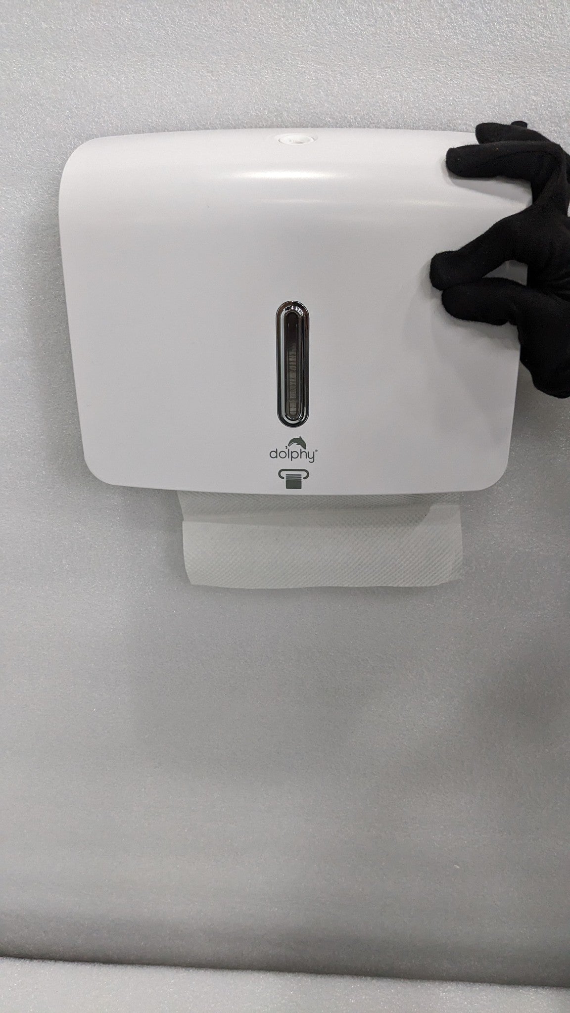 Dolphy white plaza paper towel dispenser mounted on a wall with a towel at the outlet