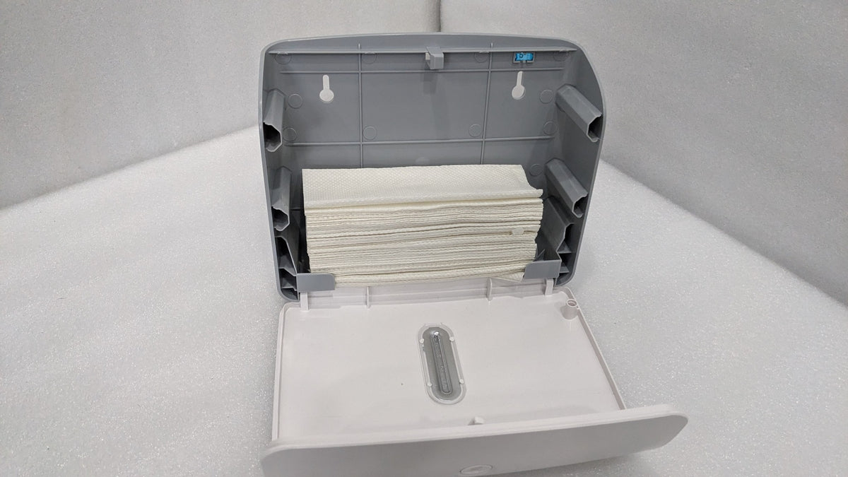Dolphy white plaza dispenser opened and loaded with a stack of folded paper towels