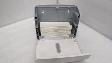 Dolphy white plaza dispenser opened and loaded with a stack of folded paper towels