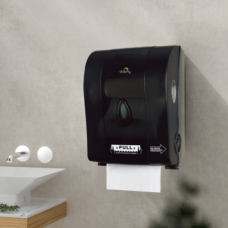 Dolphy black auto-cut paper towel dispenser mounted on a washroom wall beside a basin