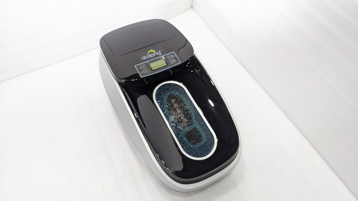 Dolphy automatic shoe cover dispenser from above, showing the PRESS foot area