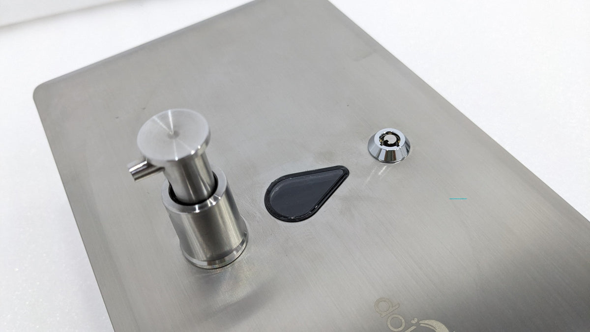 Close-up of the push button, window and key lock on the Dolphy recessed dispenser
