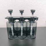 Dolphy triple dispenser with clear bottles showing the pump tubes, front view