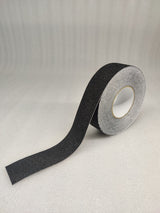Roll of Dolphy black anti-skid safety tape with a length unrolled, showing the gritty surface