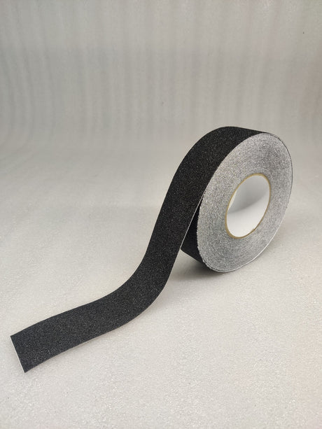Roll of Dolphy black anti-skid safety tape with a length unrolled, showing the gritty surface