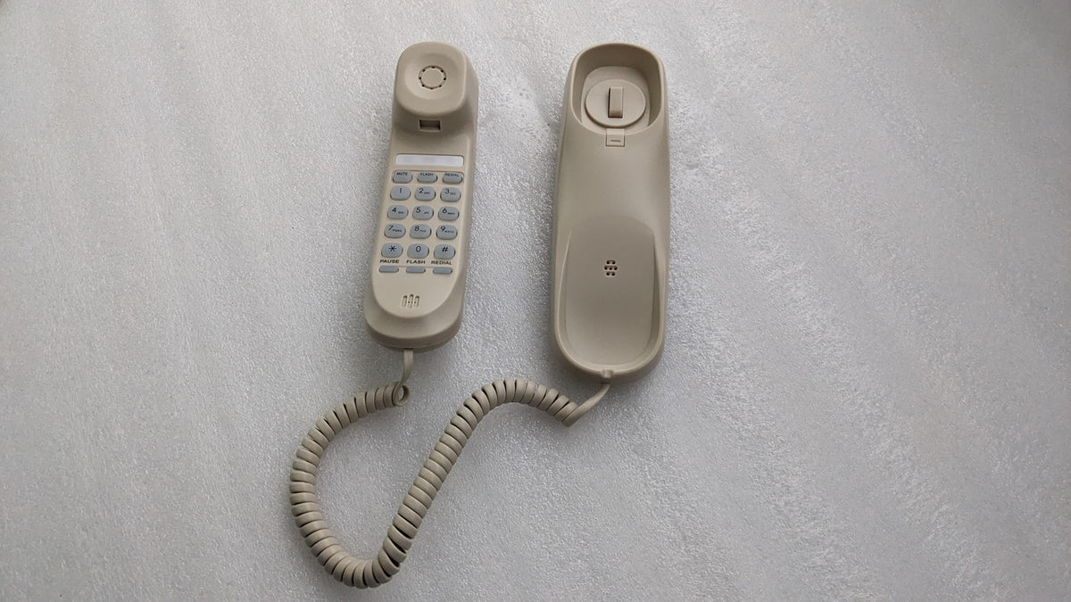 Dolphy ivory slimline telephone: handset with keypad beside its base, coiled cord