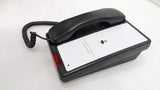 Dolphy black telephone at an angle with coiled cord