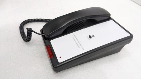 Dolphy black telephone at an angle with coiled cord