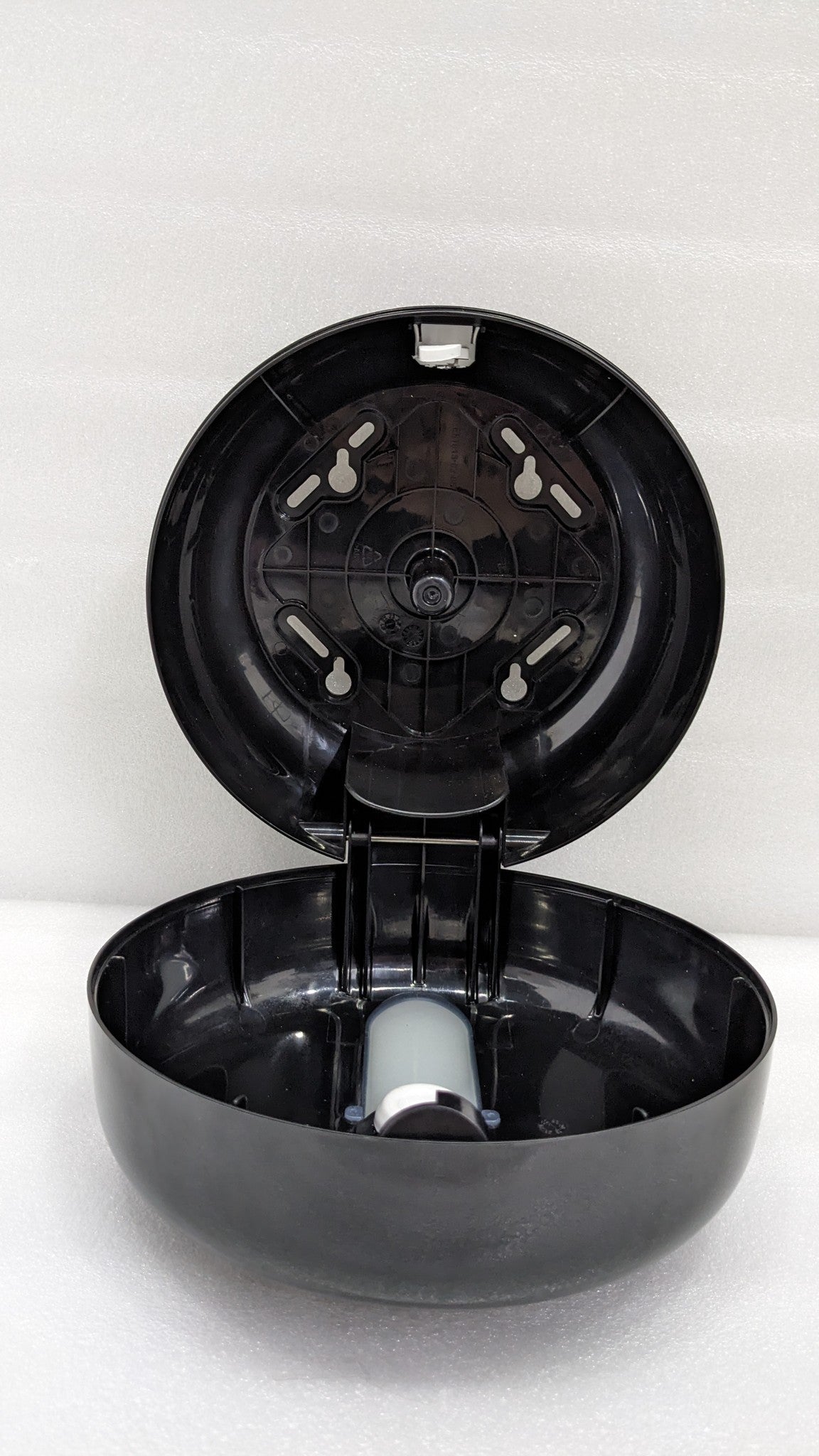 Dolphy centre-pull dispenser opened, showing the wall plate and roll holder