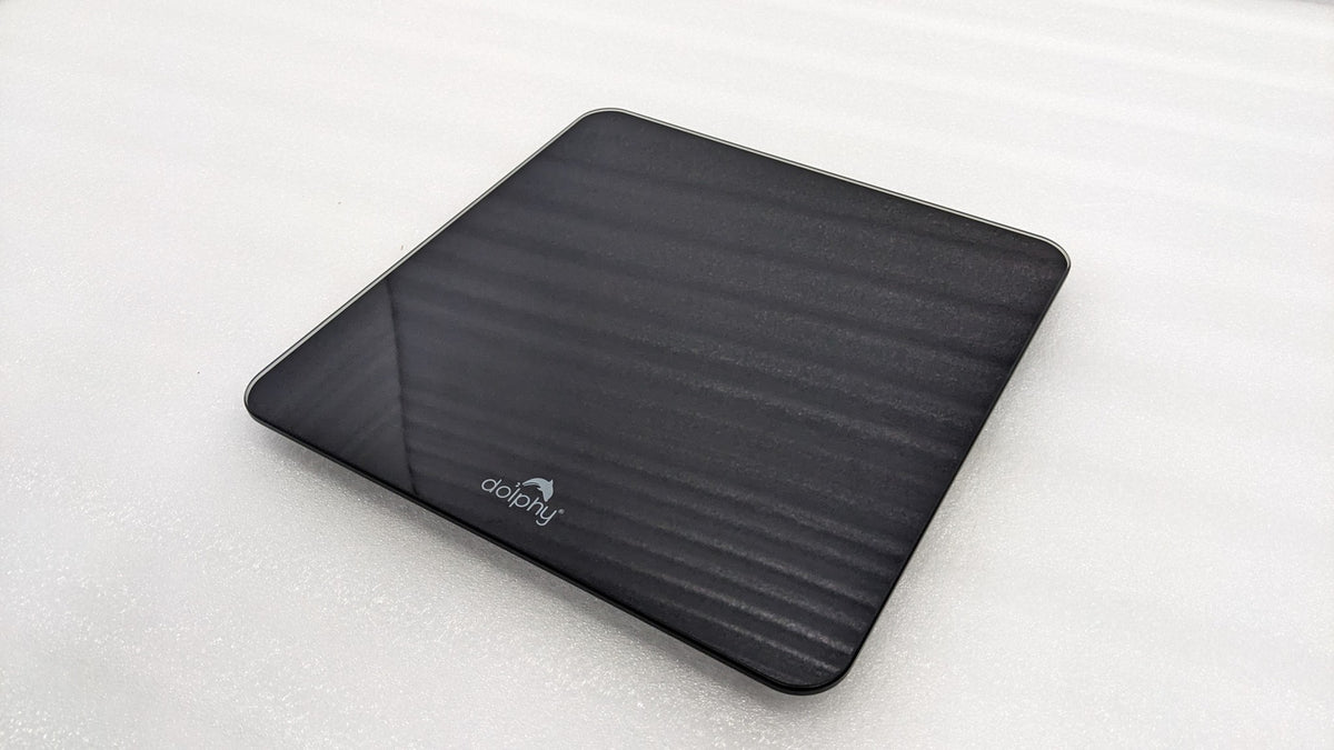 Dolphy black digital scale at an angle, showing the slim tempered glass platform
