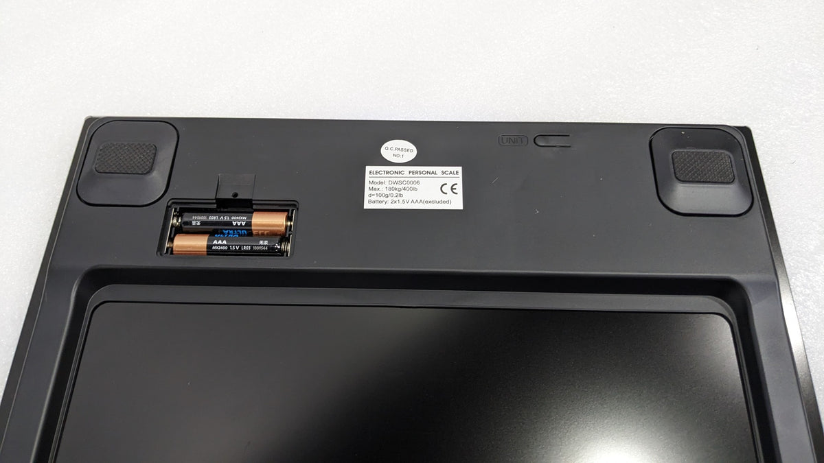 Underside of the Dolphy digital scale showing the battery compartment and non-slip feet